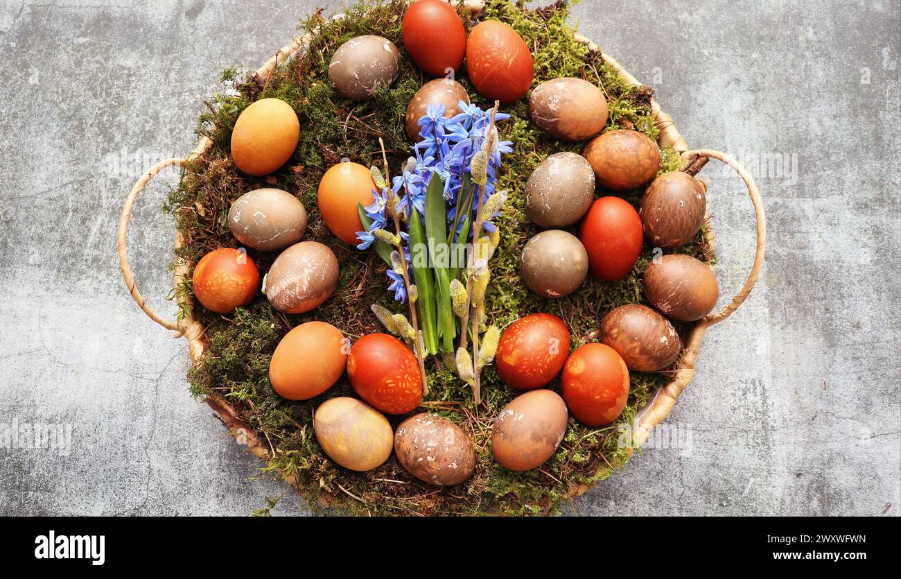 Stylish Easter table setting. Natural egg on wicker tray. Easter table decoration . Stock Photo