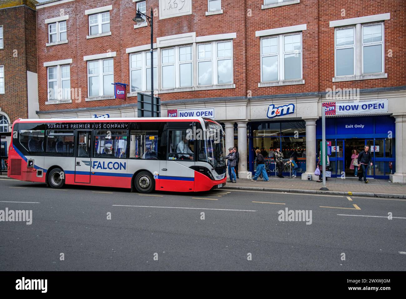Epsom Surrey, UK, April 02 2024, B&M Discount Shop With People Or Shoppers Ouside And A Parked Stationery Single Decker Falcon Bus Stock Photo