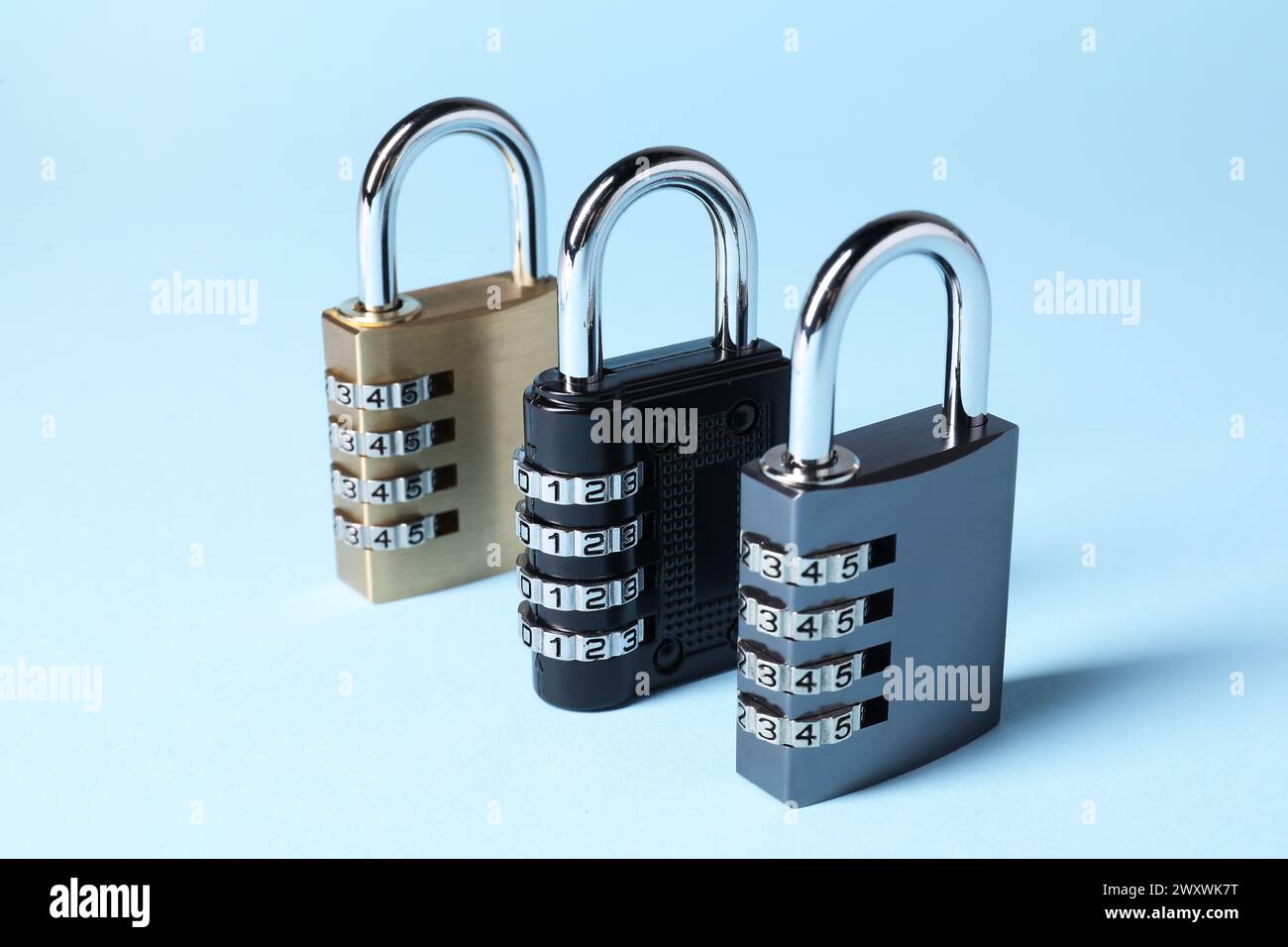 Steel combination padlocks on light blue background, closeup Stock Photo
