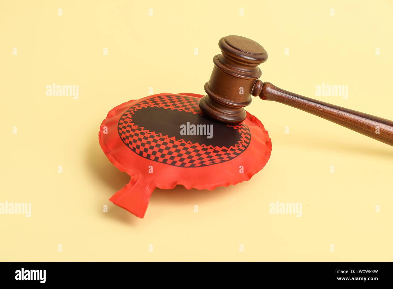 Judge gavel with whoopee cushion on color background. April Fool's Day celebration Stock Photo