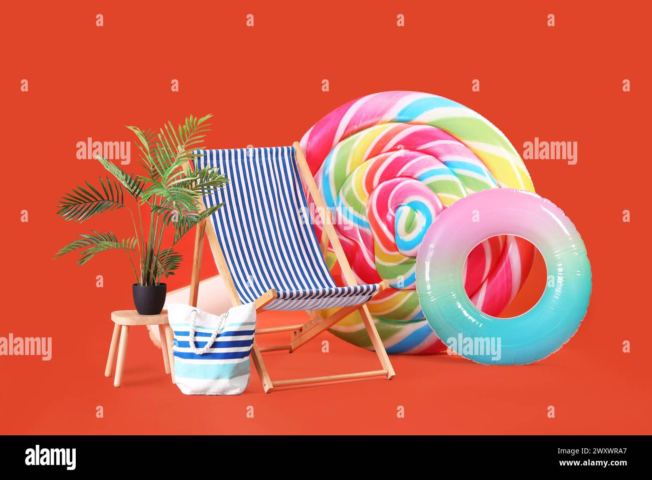 Swimming mattress in shape of candy, inflatable ring and sun lounger on orange background Stock Photo