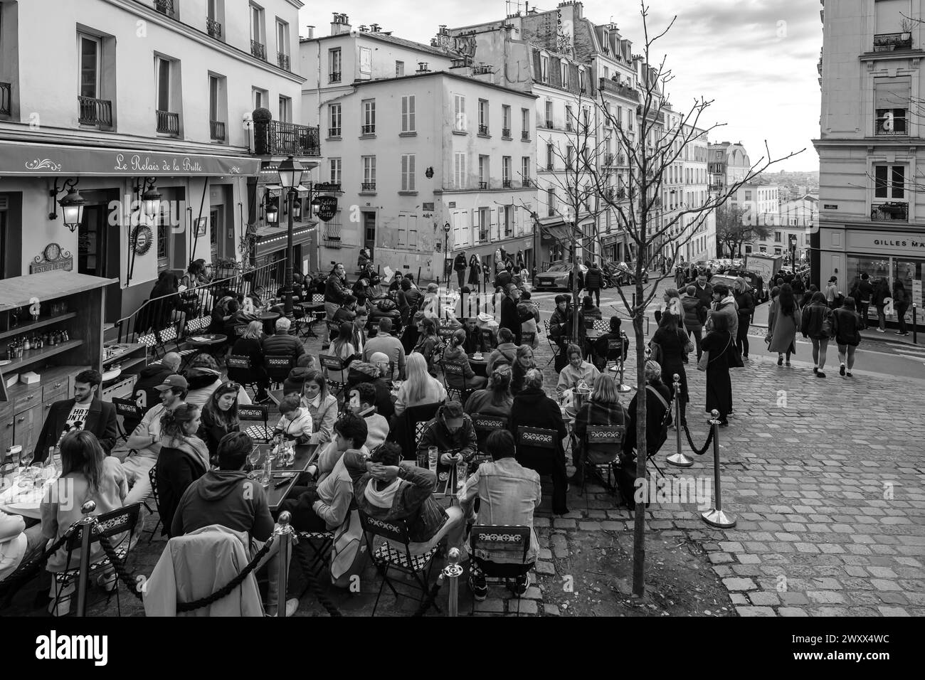 Paris, France - February 17, 2024 : View of people sitting outdoors and enjoying dinner and drinks at a cafe restaurant bistro in Paris France Stock Photo