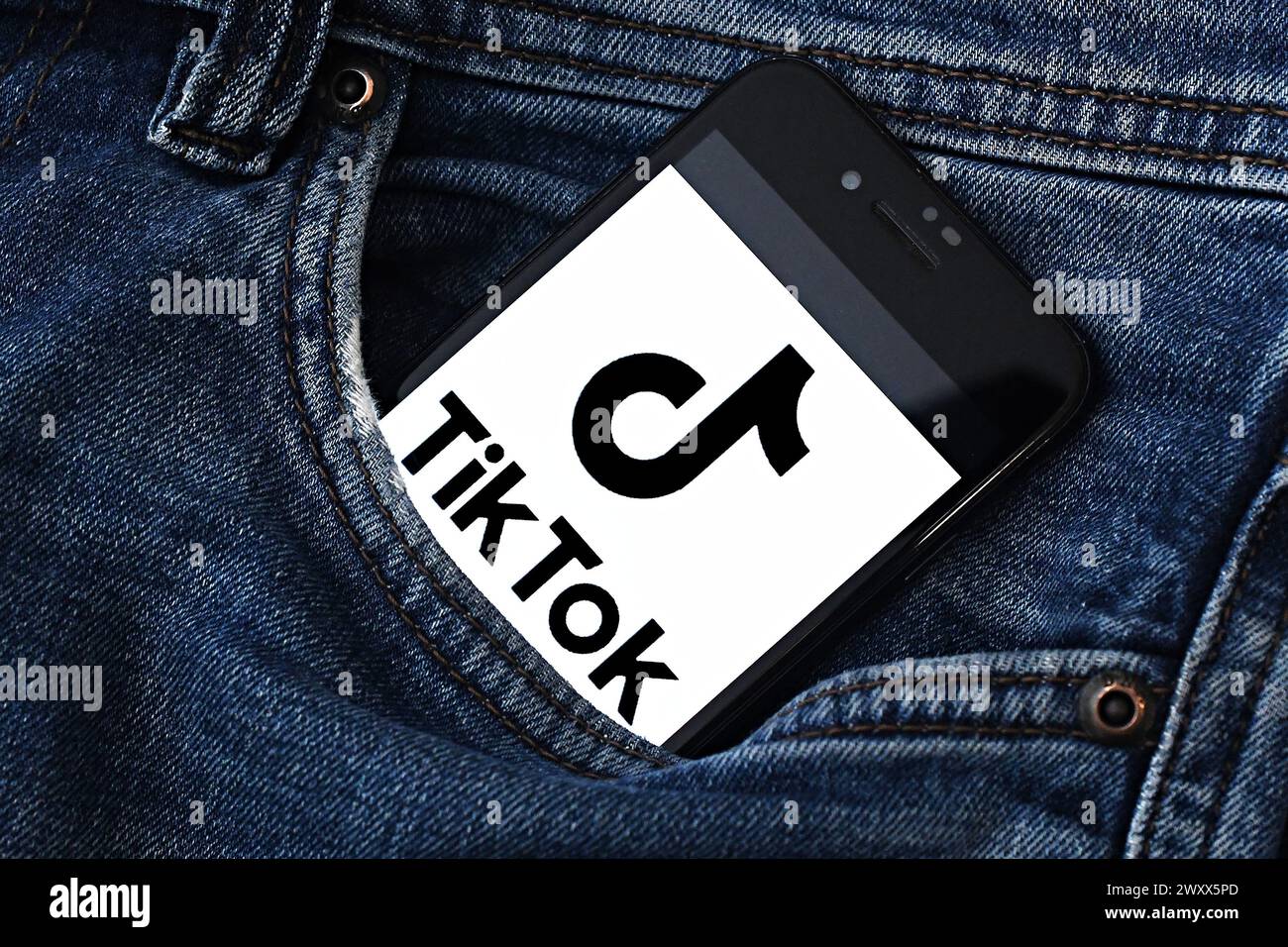 Logo of TikTok, a mobile app and social network for creating and sharing short videos by ByteDance company is seen on the screen of an smartphone.  Th Stock Photo