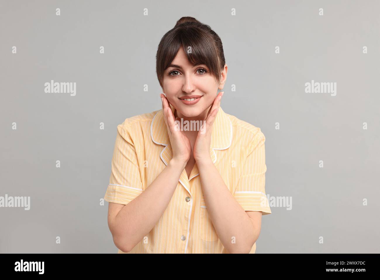 Happy woman in pyjama on grey background Stock Photo