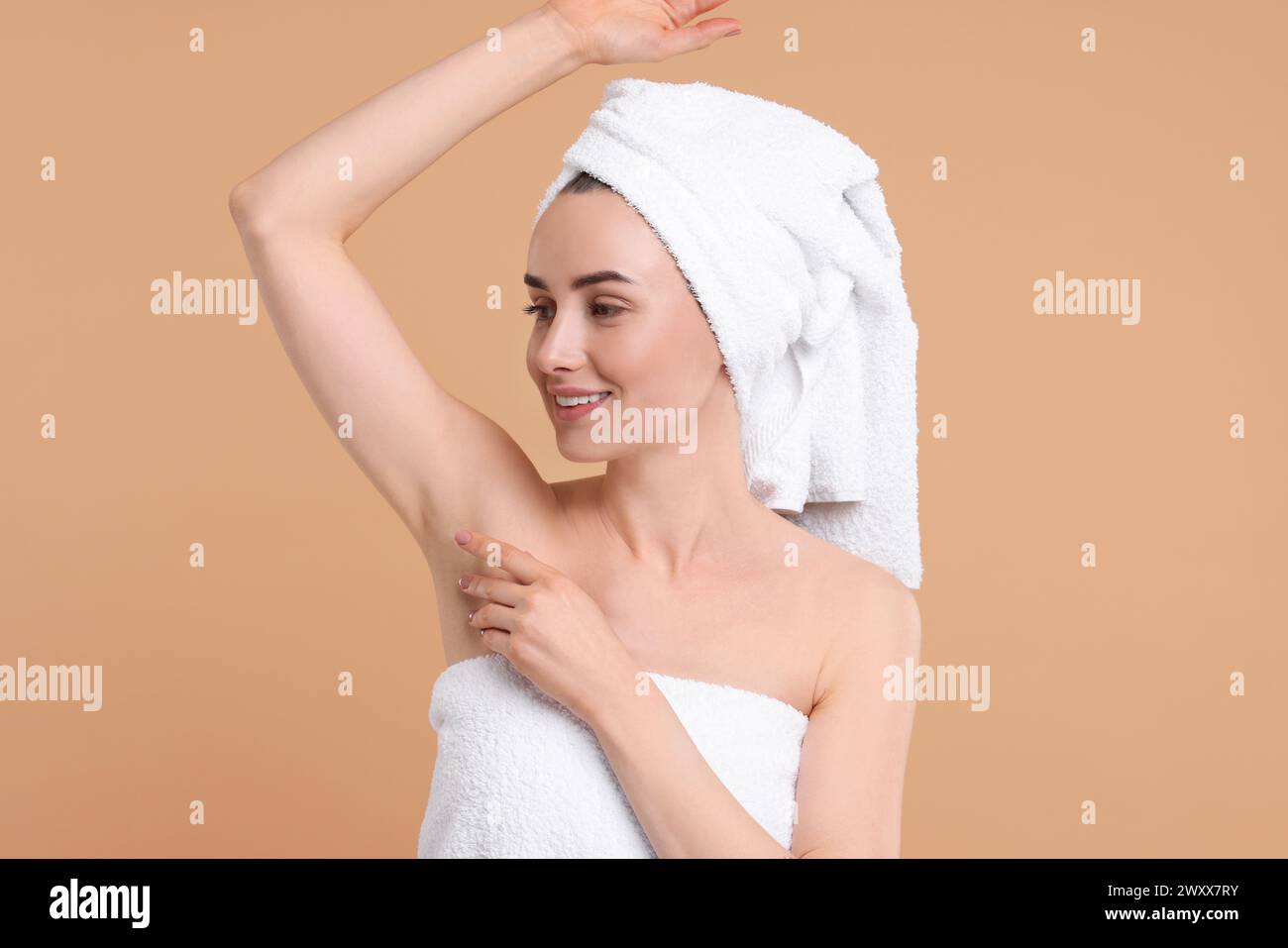 Beautiful woman showing armpit with smooth clean skin on beige background Stock Photo