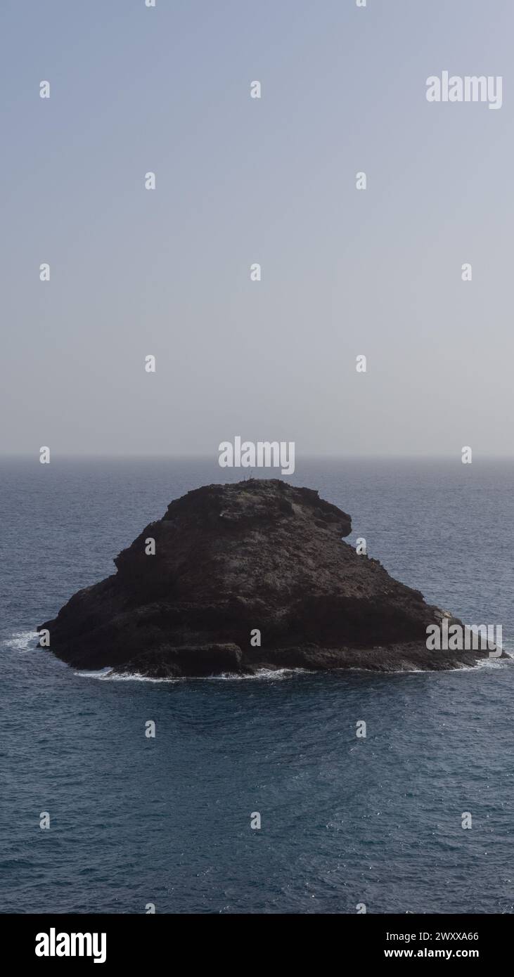 Solitary rock, ocean’s tranquil beauty Stock Photo
