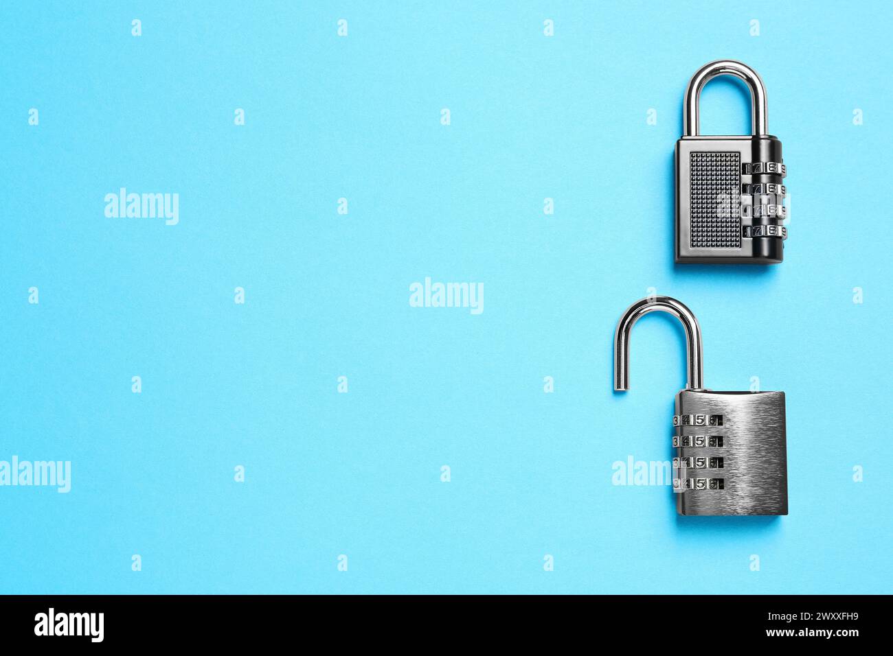 Steel combination padlocks on light blue background, top view. Space for text Stock Photo