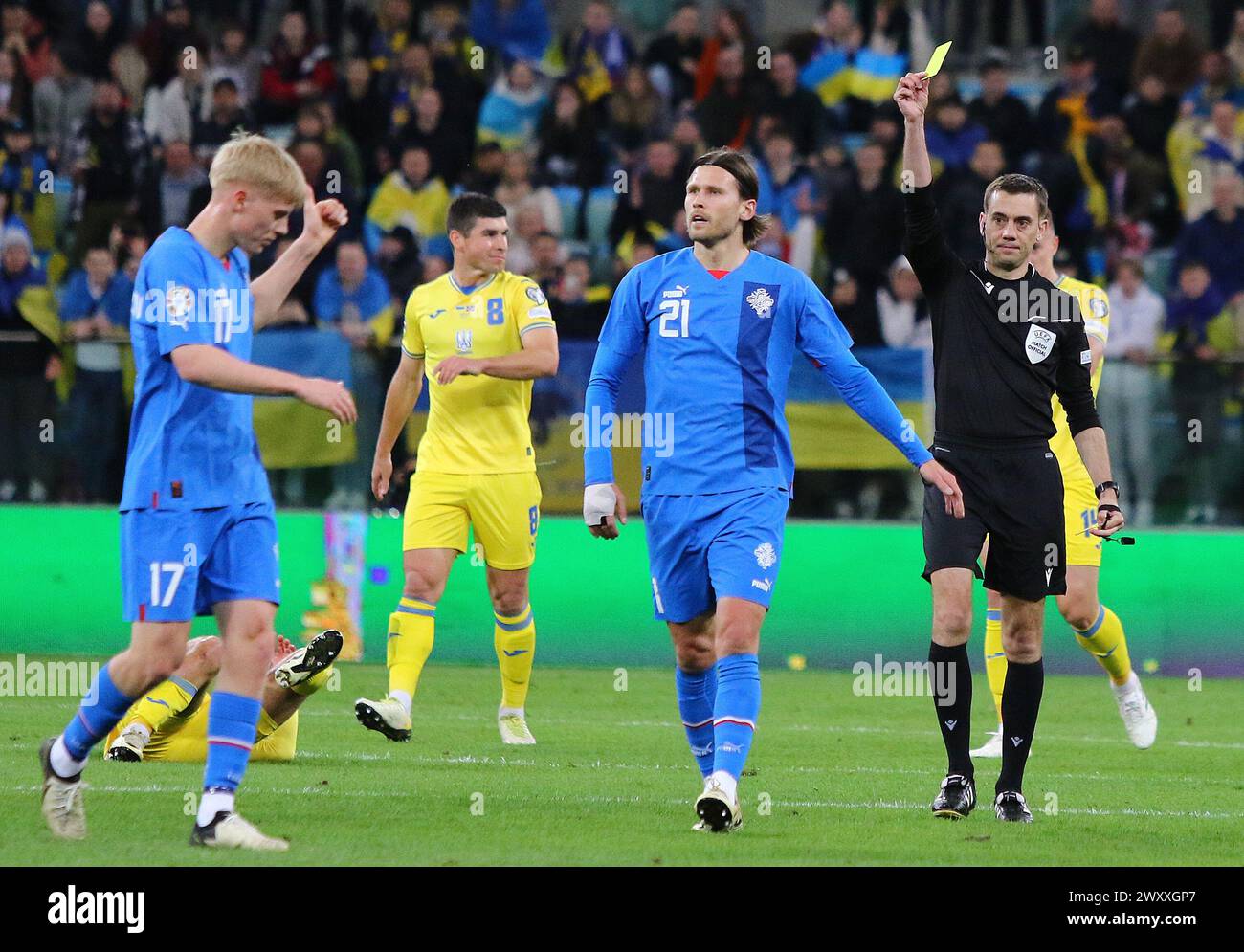 Wroclaw, Poland - March 26, 2024: Referee Clement Turpin (FRA) shows yellow card to Arnar Haraldsson of Iceland (#17) during the UEFA EURO 2024 Play-off game Ukraine v Iceland at Tarczynski Arena Stock Photo