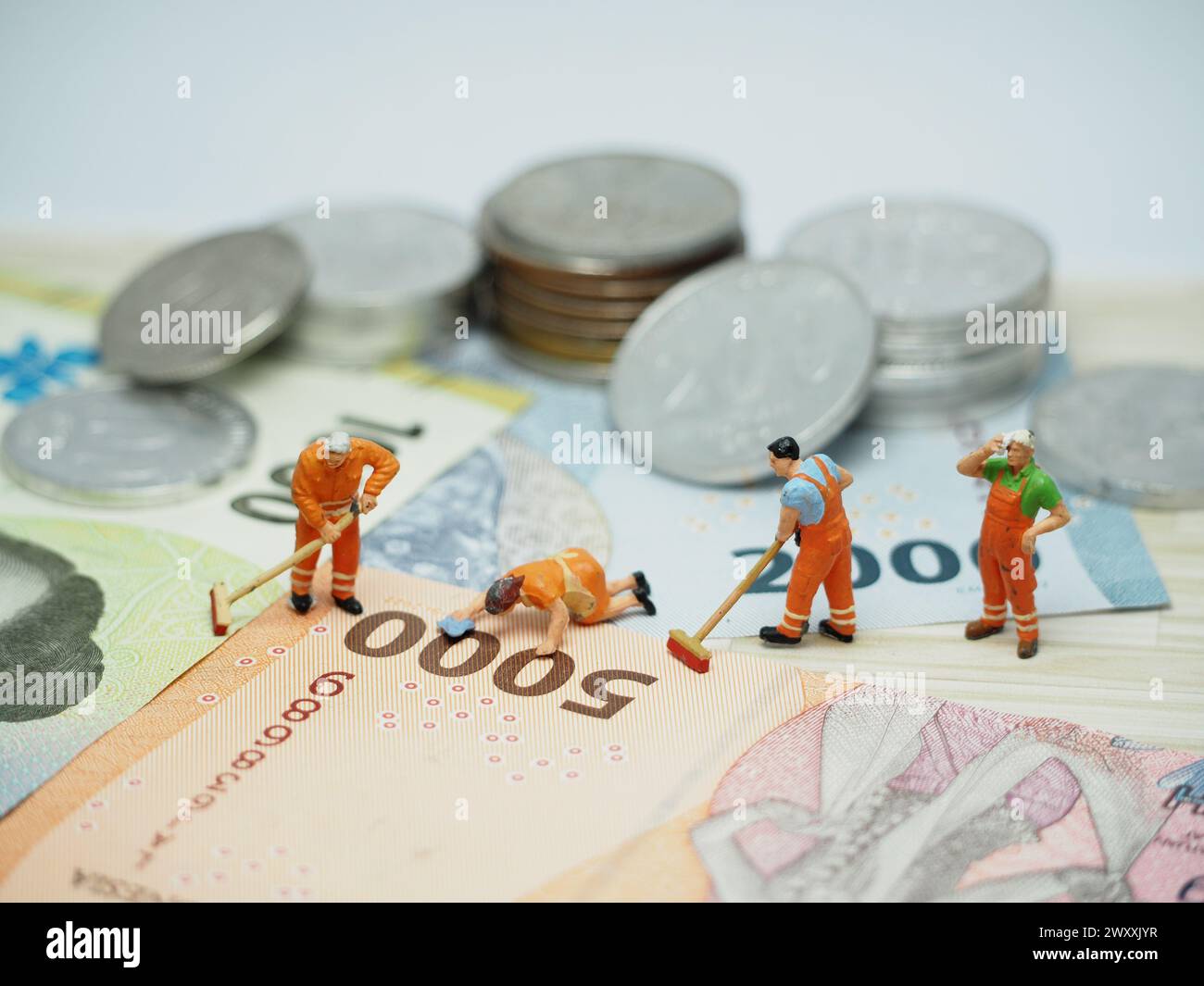 Miniature toy and unfocus money at table with blurred background. Money laundry conceptual design. Stock Photo