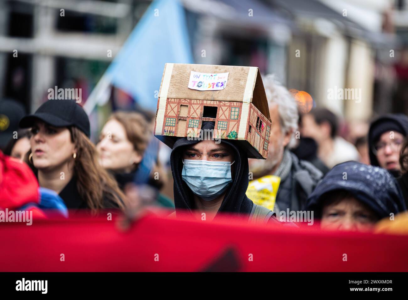 A protester seen with a paper house on his head during the demonstration against housing crisis. Thousands of people attended the demonstration for the right to housing, in Paris. The movement organized by the association 'DAL' Droit Au Logement (Right to Housing), focused on denouncing the start of evictions that will begin at the beginning of April. It was also demanded a reduction in rents, the requisition of empty houses for rent, accommodation for all inhabitants and an end to real estate speculation. (Photo by Telmo Pinto/SOPA Images/Sipa USA) Stock Photo