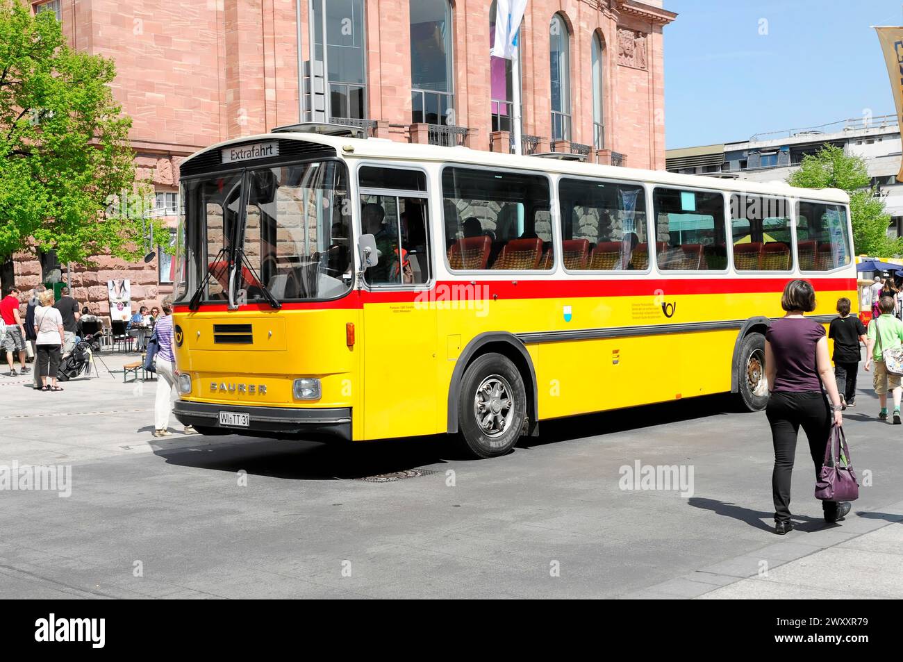 Yellow city bus with red accents in use in an urban environment, Mainz, Rhineland-Palatinate, Germany Stock Photo