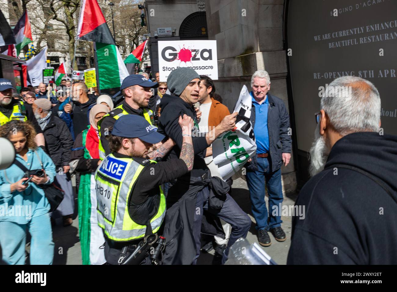 Person being detained by police at a protest against the escalation of military action in Gaza as the conflict between Israel and Hamas continues. Stock Photo