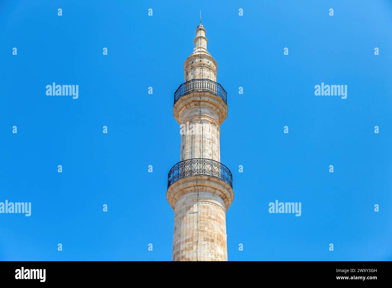 Neratze Mosque iconic Minaret tower at Rethymno city, Crete island, Greece. Under view, upper part of Islamic monument on blue sky background. Stock Photo
