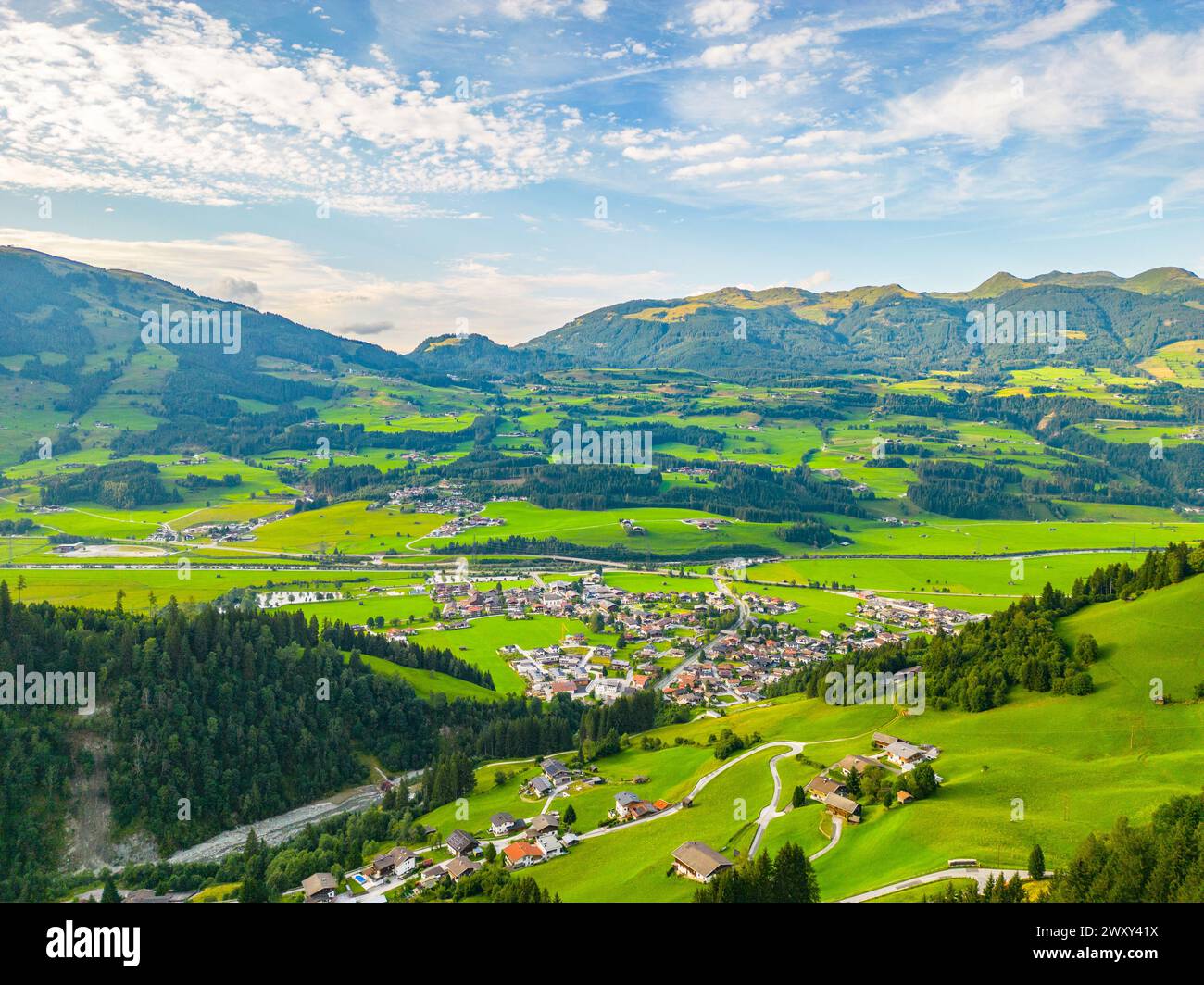 A scenic view of Hollersbach im Pinzgau with lush green fields and rolling hills under a clear sky. Hohe Tauern, Austria Stock Photo