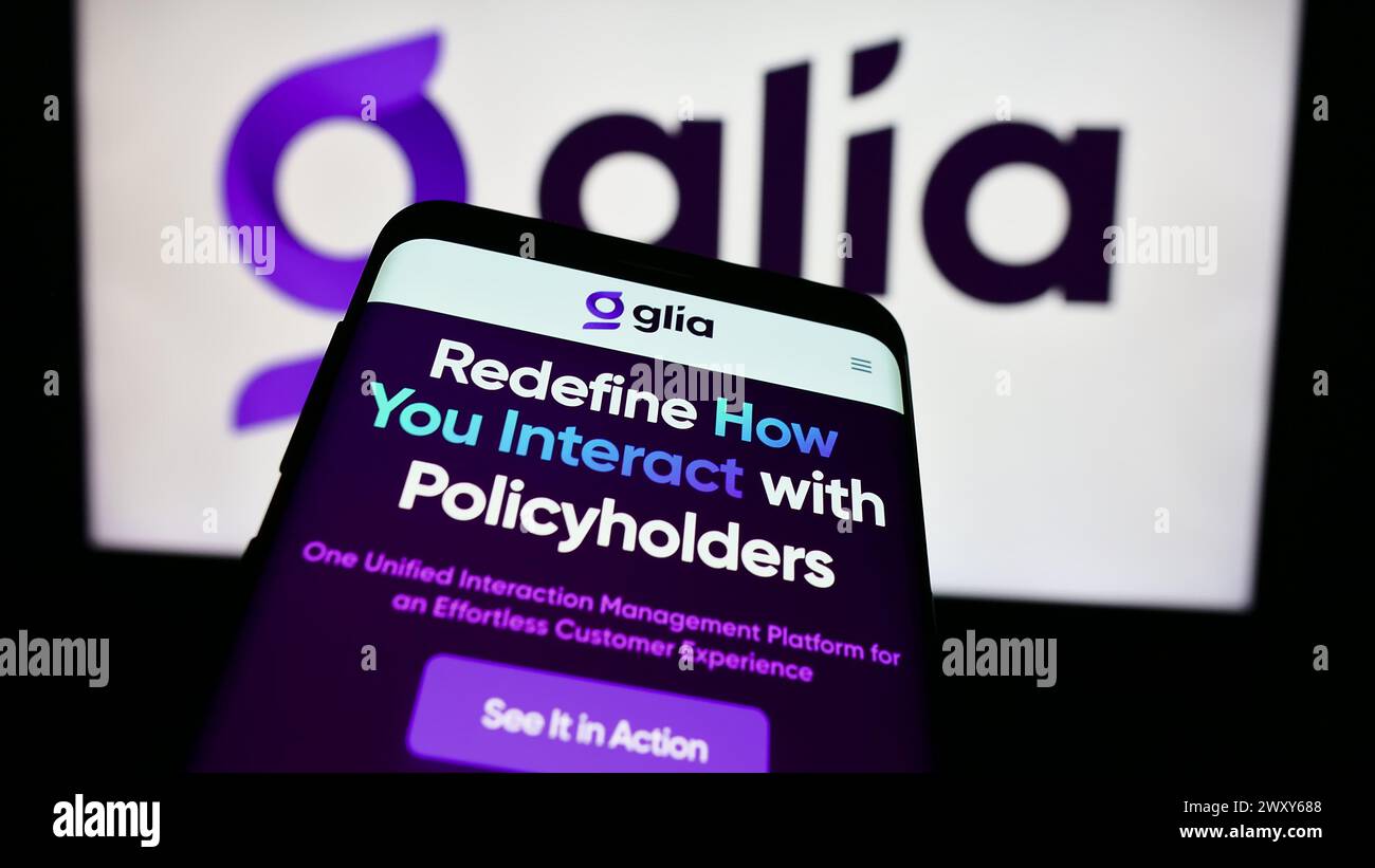 Mobile phone with website of US customer interaction company Glia Technologies Inc. in front of business logo. Focus on top-left of phone display. Stock Photo