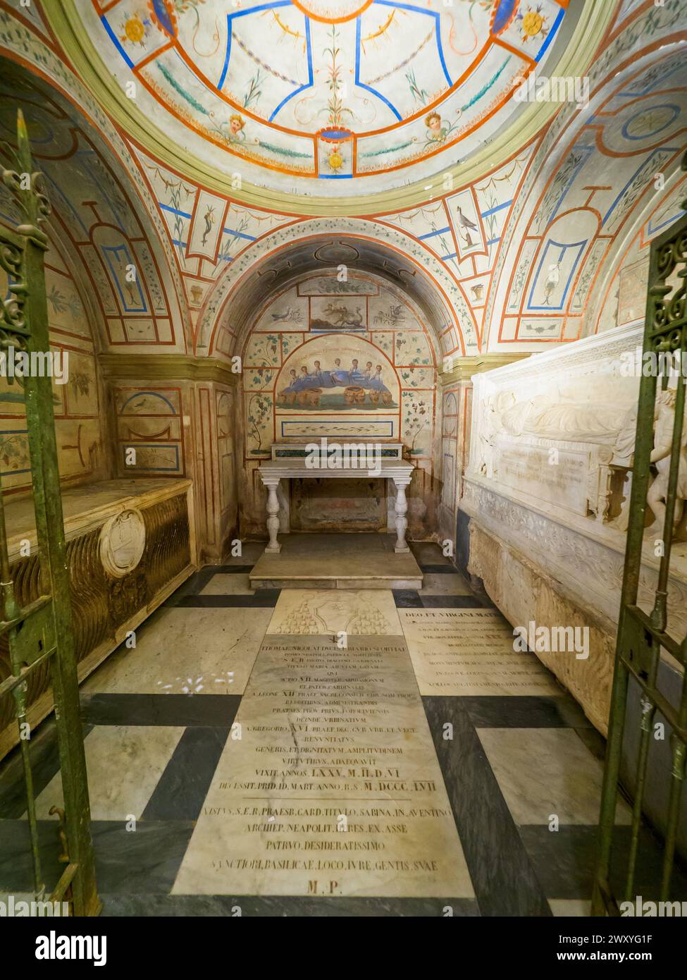 The vast crypt under the main altar,  built by Luigi Carimini in 1869-71 bringing together, in addition to the remains of the titular apostles Philip and James, the relics of various other martyrs that came to light during these excavations, and the tombs of two of Riario who once had the right to burial at the presbytery. The tempera decorations of the ambulatory are inspired by those of the catacombs of San Callisto and Domitilla. - Basilica dei Santi XII Apostoli - Rome Italy Stock Photo