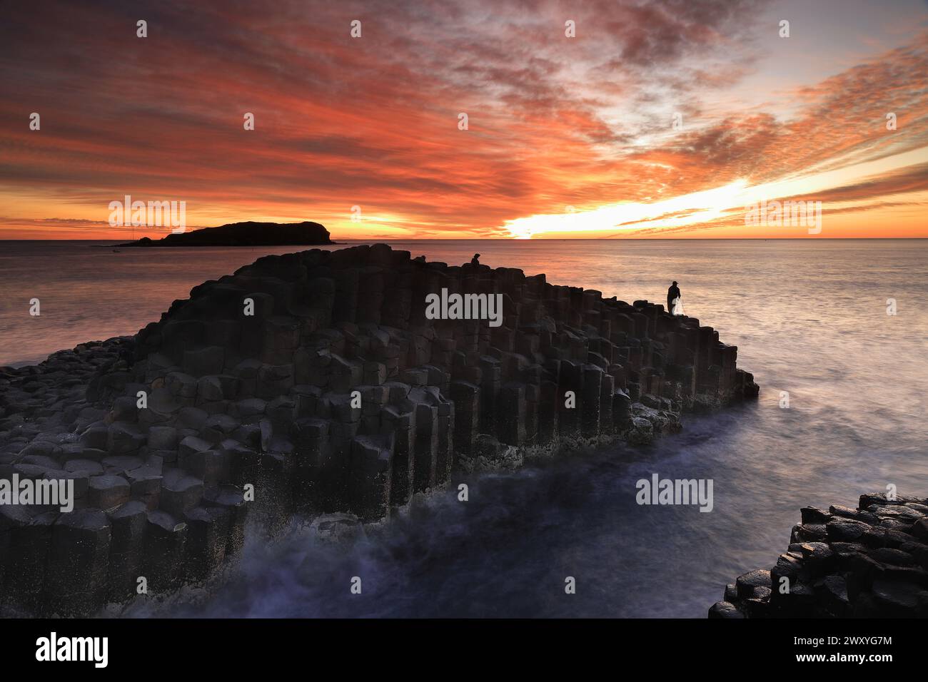 Sunrise at Giants Causeway Fingal Head, NSW, Australia with Cook Island in the distance Stock Photo