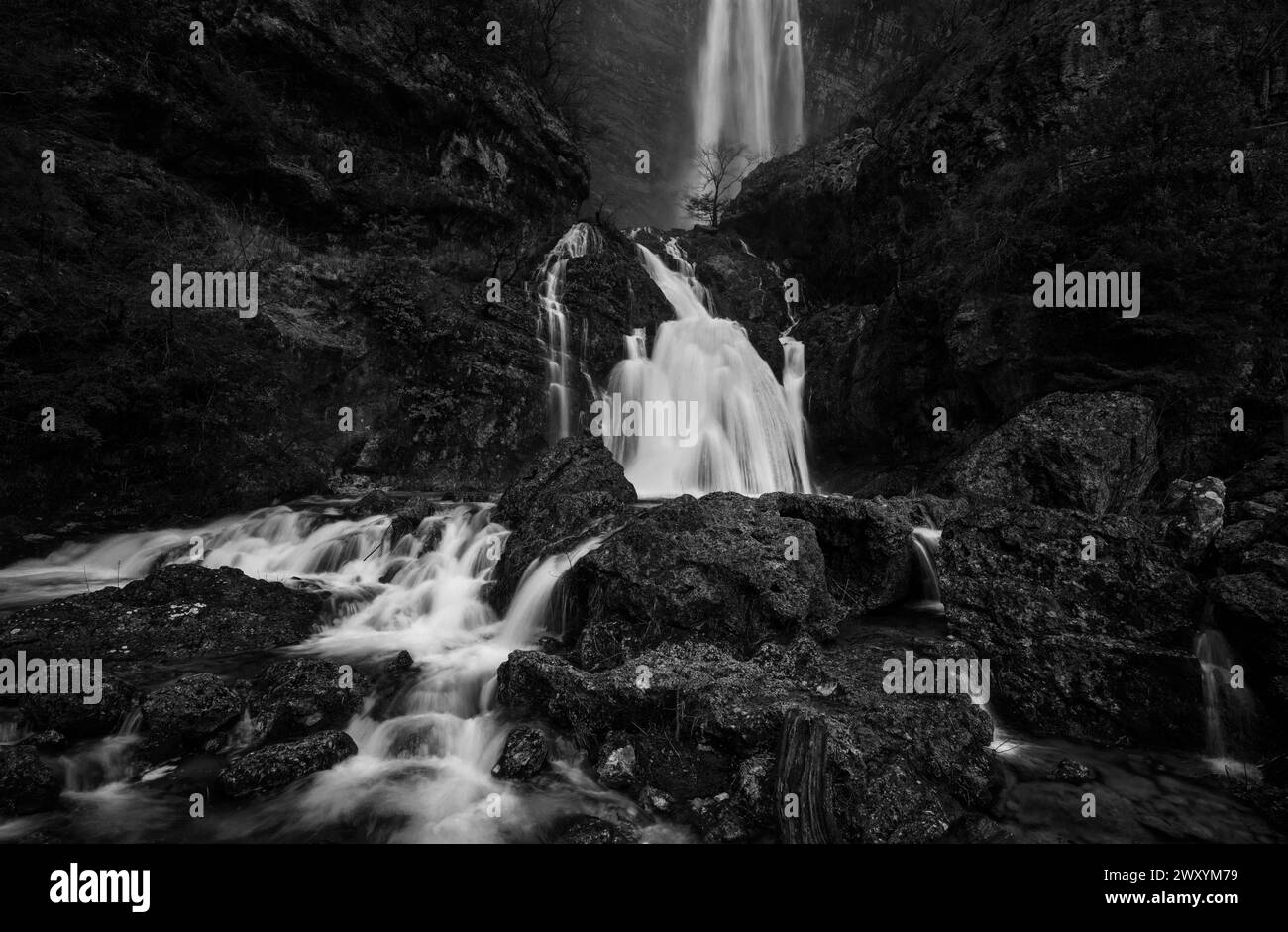 The powerful Rio Mundo Waterfall cascades over rocks in a stunning black and white landscape, capturing the essence of motion Stock Photo