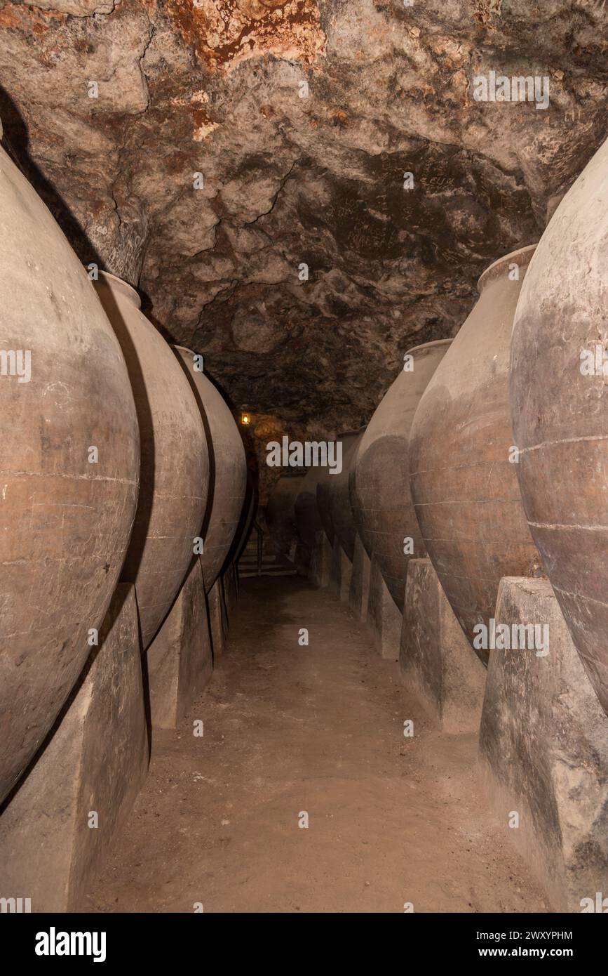 Inside a dimly lit Chinchon winery cellar, a corridor lined with large