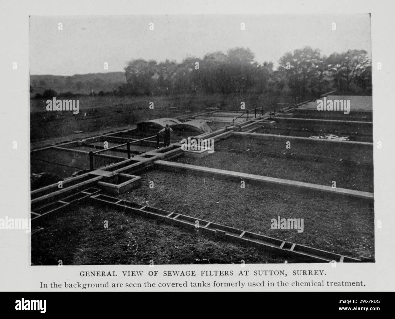 GENERAL VIEW OF SEWAGE FILTERS AT SUTTON, SURREY, England. In the background are seen the covered tanks formerly used in the chemical treatment. from the Article BACTERIAL PROCESSES OF SEWAGE PURIFICATION. By Rudolph Hering. from The Engineering Magazine Devoted to Industrial Progress Volume XV 1898 The Engineering Magazine Co Stock Photo