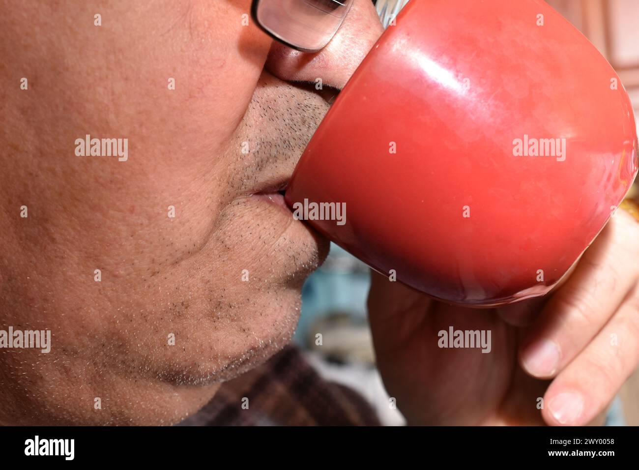 The picture shows an elderly man drinking from a cup. Stock Photo