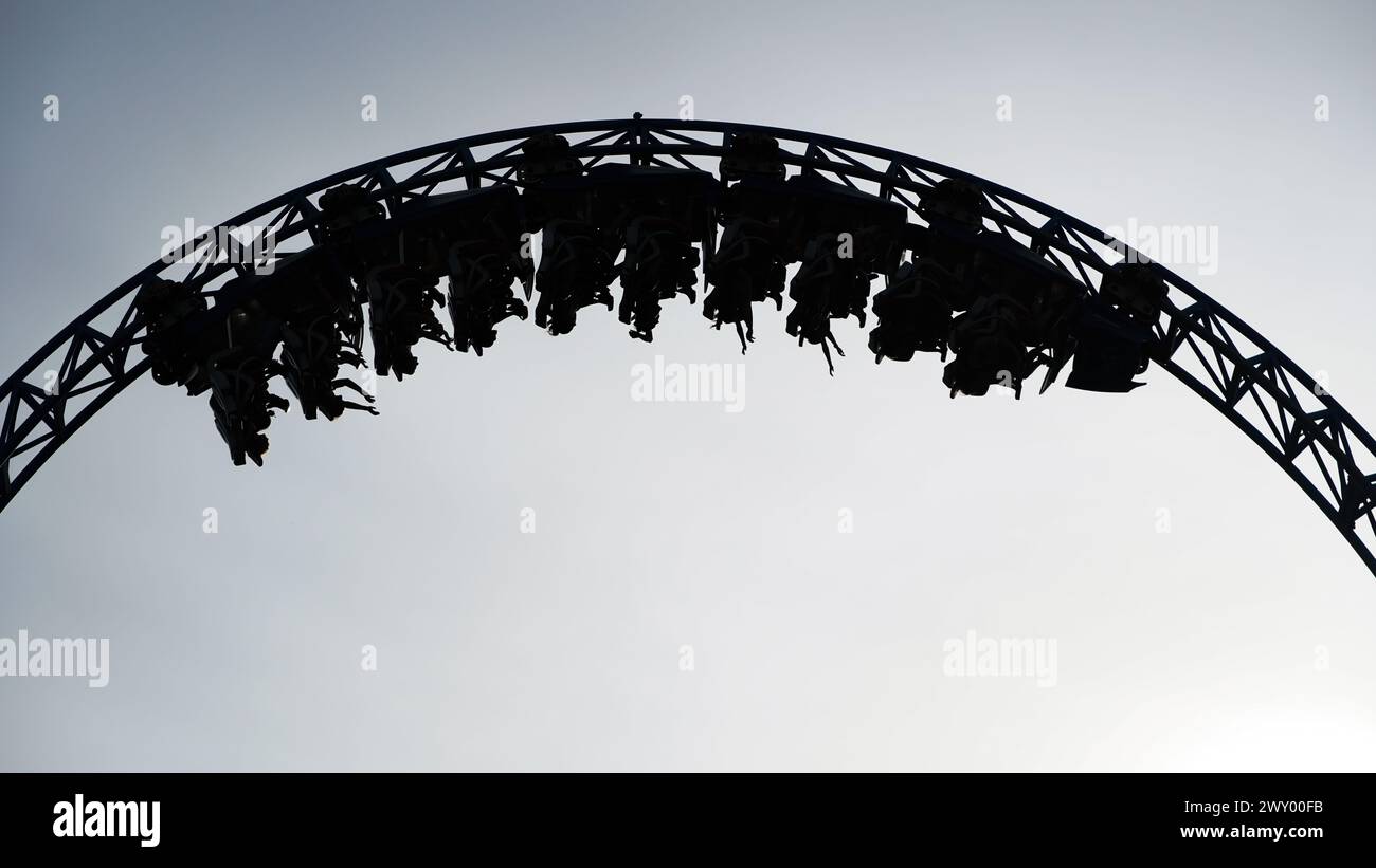 Young people have fun on the 'Blue Fire' rollercoaster at the 'Europa-Park' theme park. They scream, laugh and enjoy their summer holiday in the beaut Stock Photo