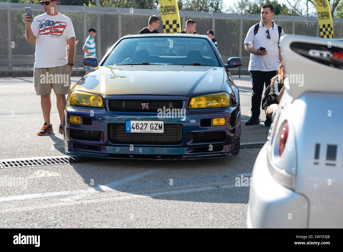 Front view of a tenth generation Nissan Skyline GT-R34 with a changing iridescent color at a Japanese sports car meet. Stock Photo