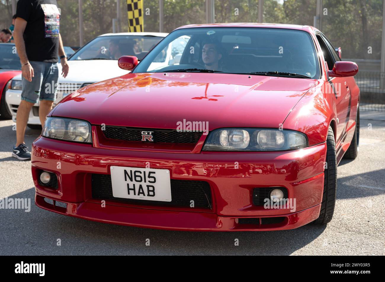Front view of a red ninth-generation Nissan Skyline GT-R33 at a Japanese sports car meet. Stock Photo
