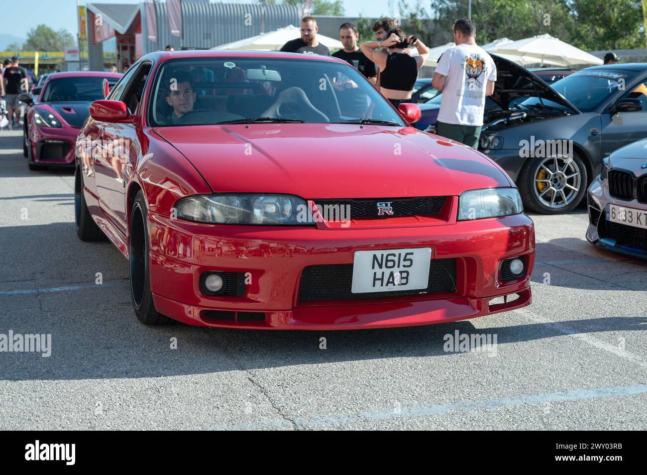Front view of a red ninth-generation Nissan Skyline GT-R33 at a Japanese sports car meet. Stock Photo