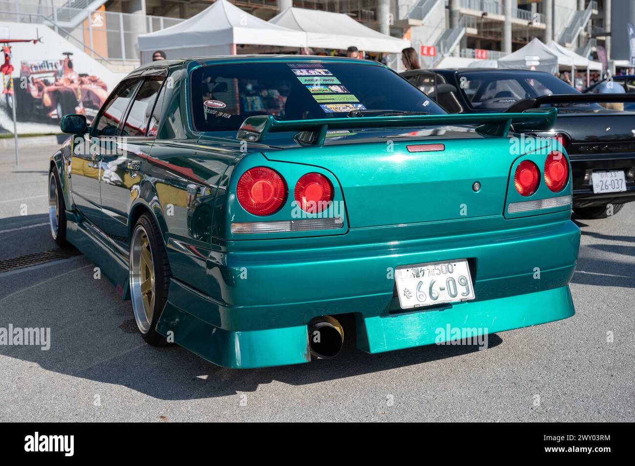 Rear view of a tenth generation green Nissan Skyline GT R34 at a Japanese car meet. Has an extended rear bumper Stock Photo