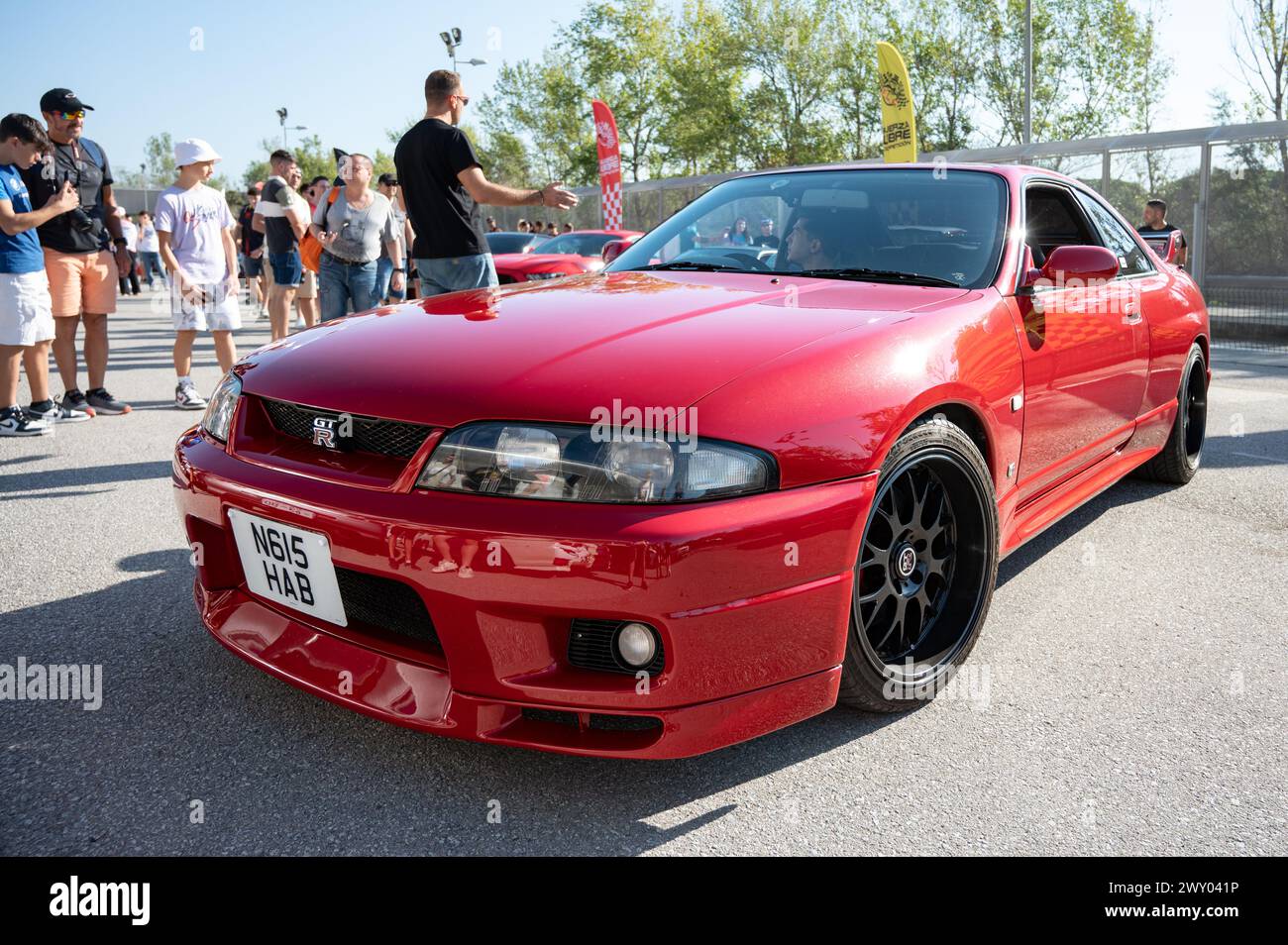 Front view of a red ninth-generation Nissan Skyline GT-R33 at a Japanese sports car meet. Stock Photo