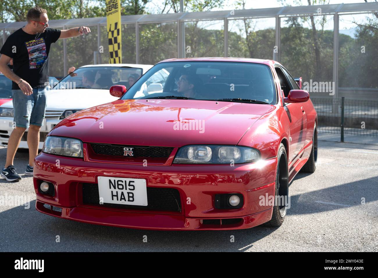 Front view of a red ninth-generation Nissan Skyline GT-R33 at a Japanese sports car meet. Stock Photo