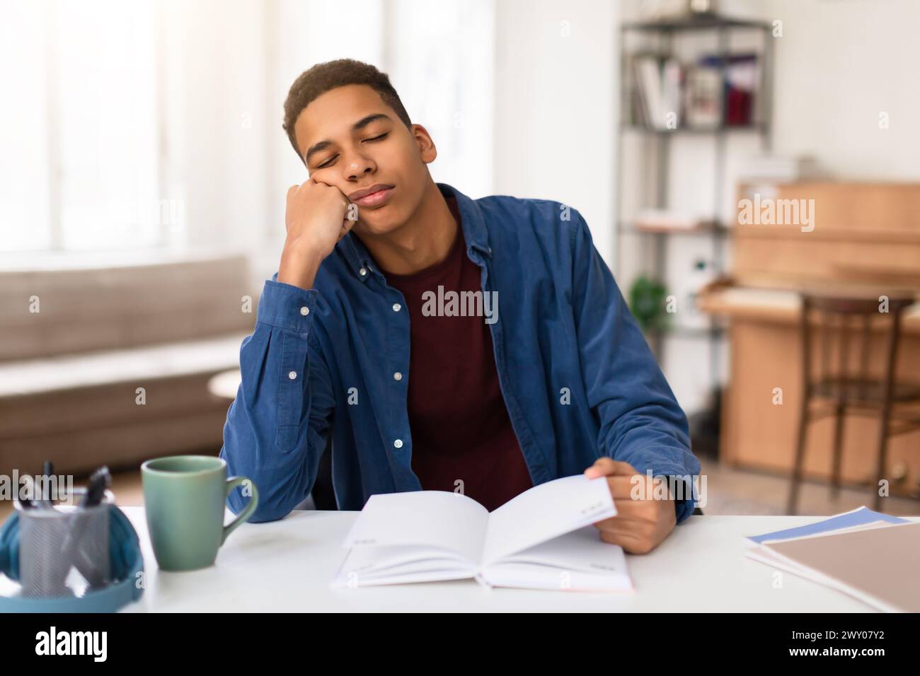 Exhausted student guy asleep on study books Stock Photo