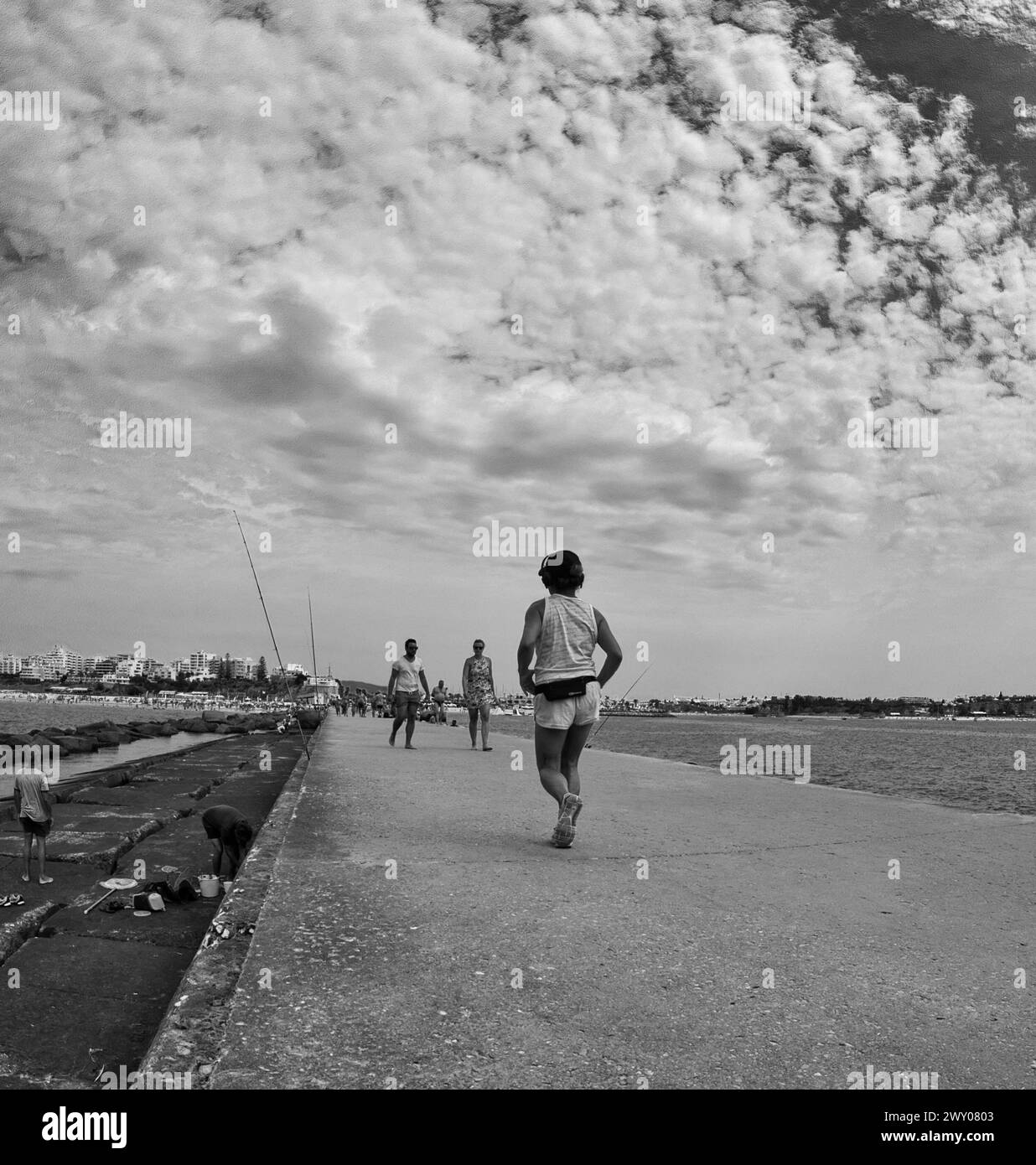 People walking on the Portimão pier next to the sea at Praia da Rocha on a summer day. Stock Photo