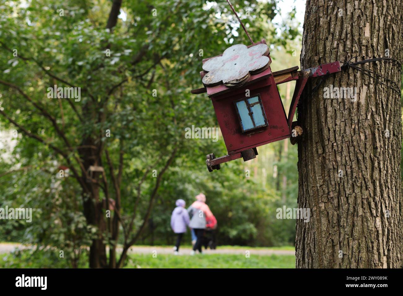 Beautiful small house with blue window on tree. This is the feeder for squirrels and birds Stock Photo