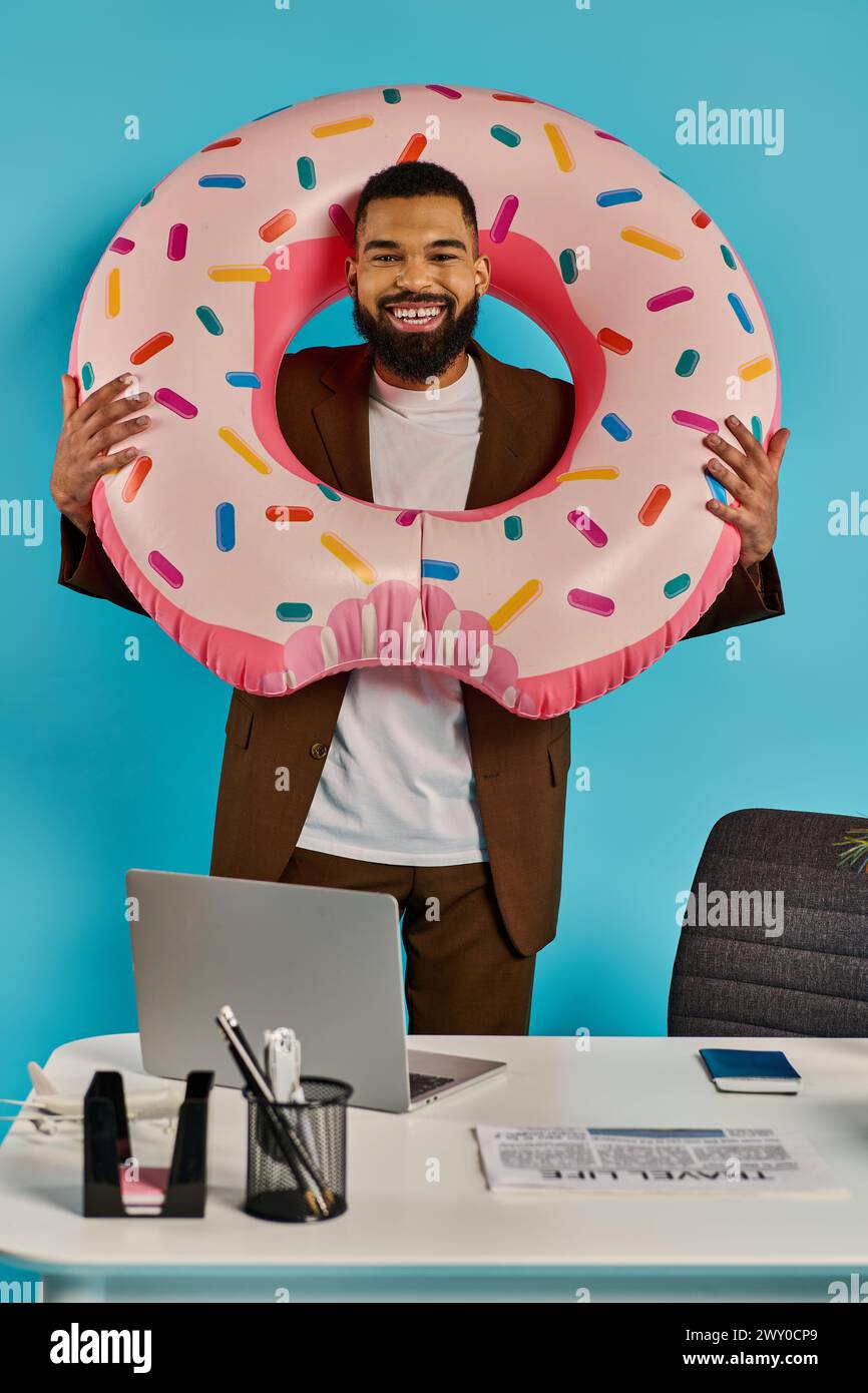 A man playfully holds a giant donut in front of his face, peeking through the hole with a mischievous smile. Stock Photo