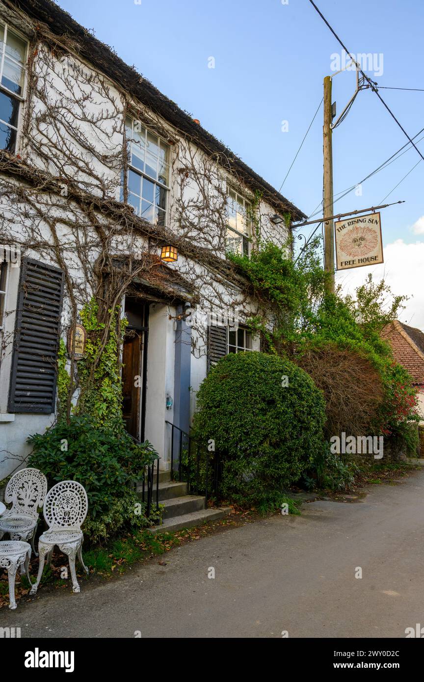 The front facade and sign of The Rising Sun, an old pub in Nutbourne village near Pulborough in West Sussex, England. Stock Photo