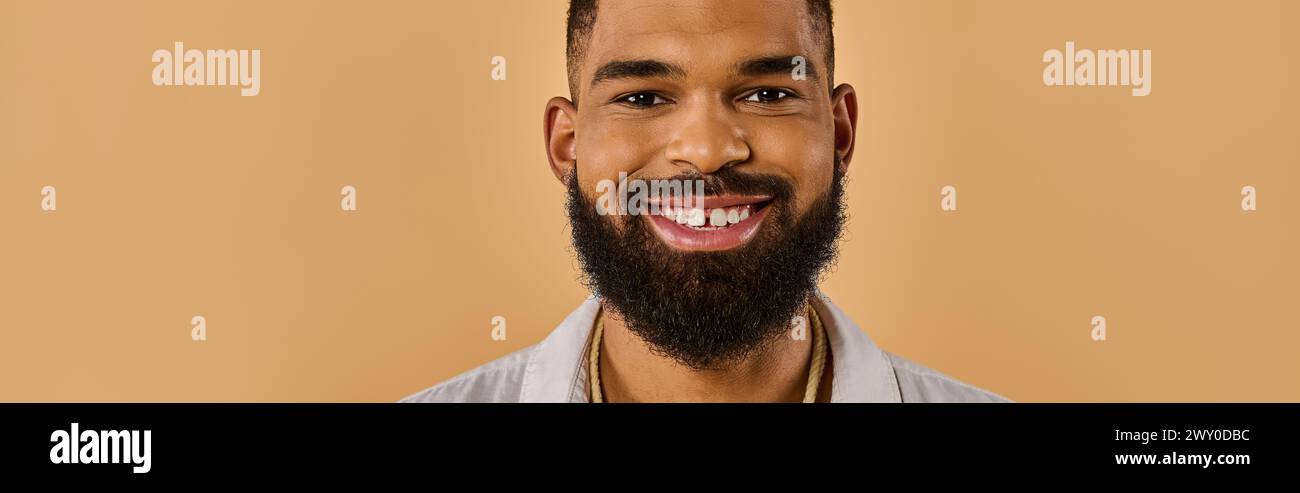 A man with a full, bushy beard grins warmly at the camera, his eyes sparkling with happiness and a hint of mischief. Stock Photo