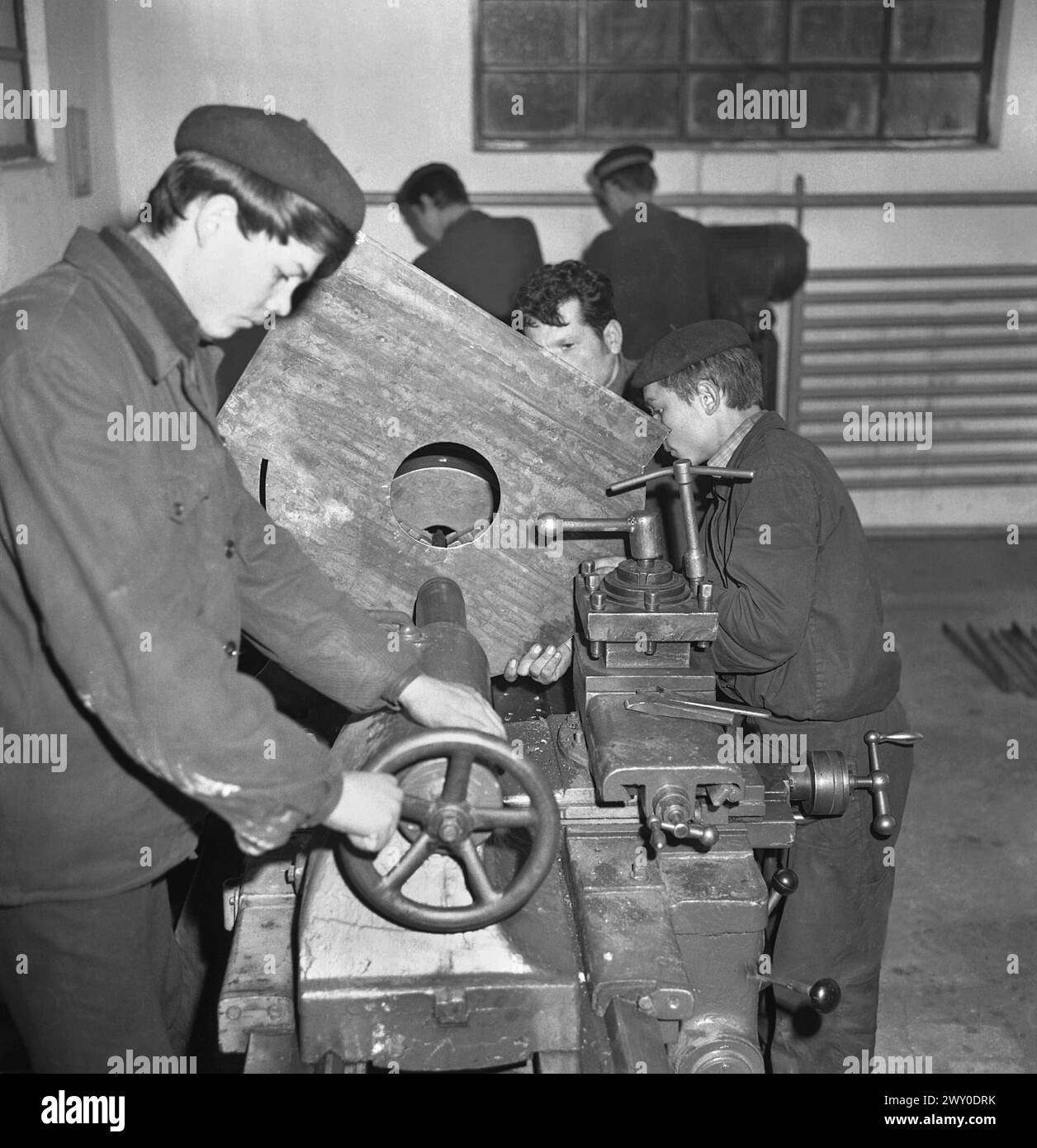 Socialist Republic of Romania in the 1970s. Students learning how to operate a lathe in a state-owned workshop. Stock Photo
