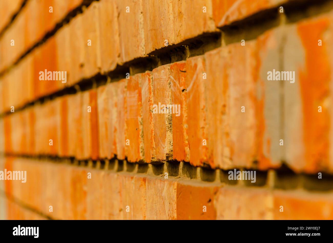 An abstract photograph of the layout of bricks making up the exterior wall of a house. Stock Photo