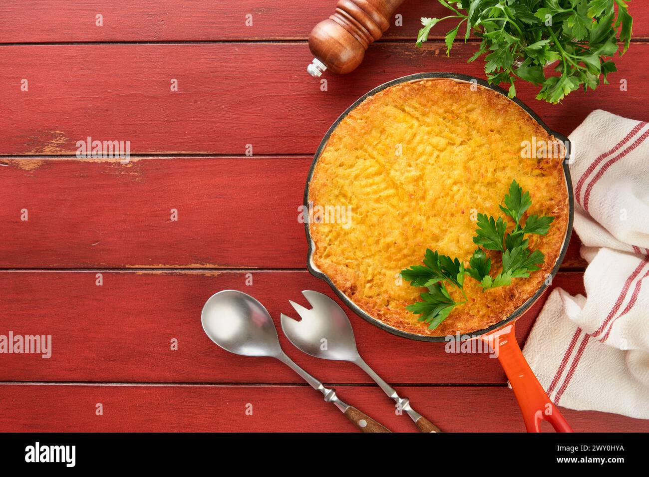 Shepherd's Pie with ground beef, peas, carrots, onions, potato and cheese on old wooden background in cast iron pan. Traditional British dish homemade Stock Photo