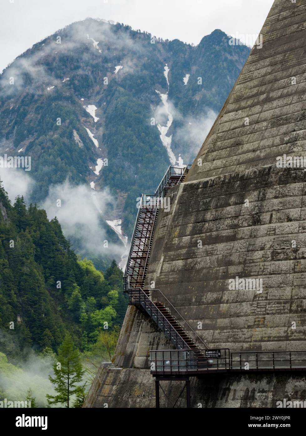 Metal steps leading vertically up the wall of a huge hydrolectric dam in Japan Stock Photo