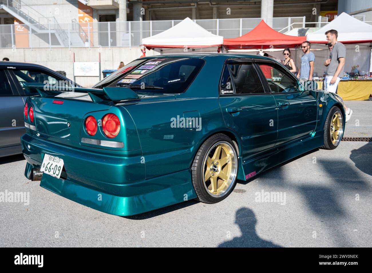 Rear view of a tenth generation green Nissan Skyline GT R34 at a Japanese car meet. Has an extended rear bumper Stock Photo