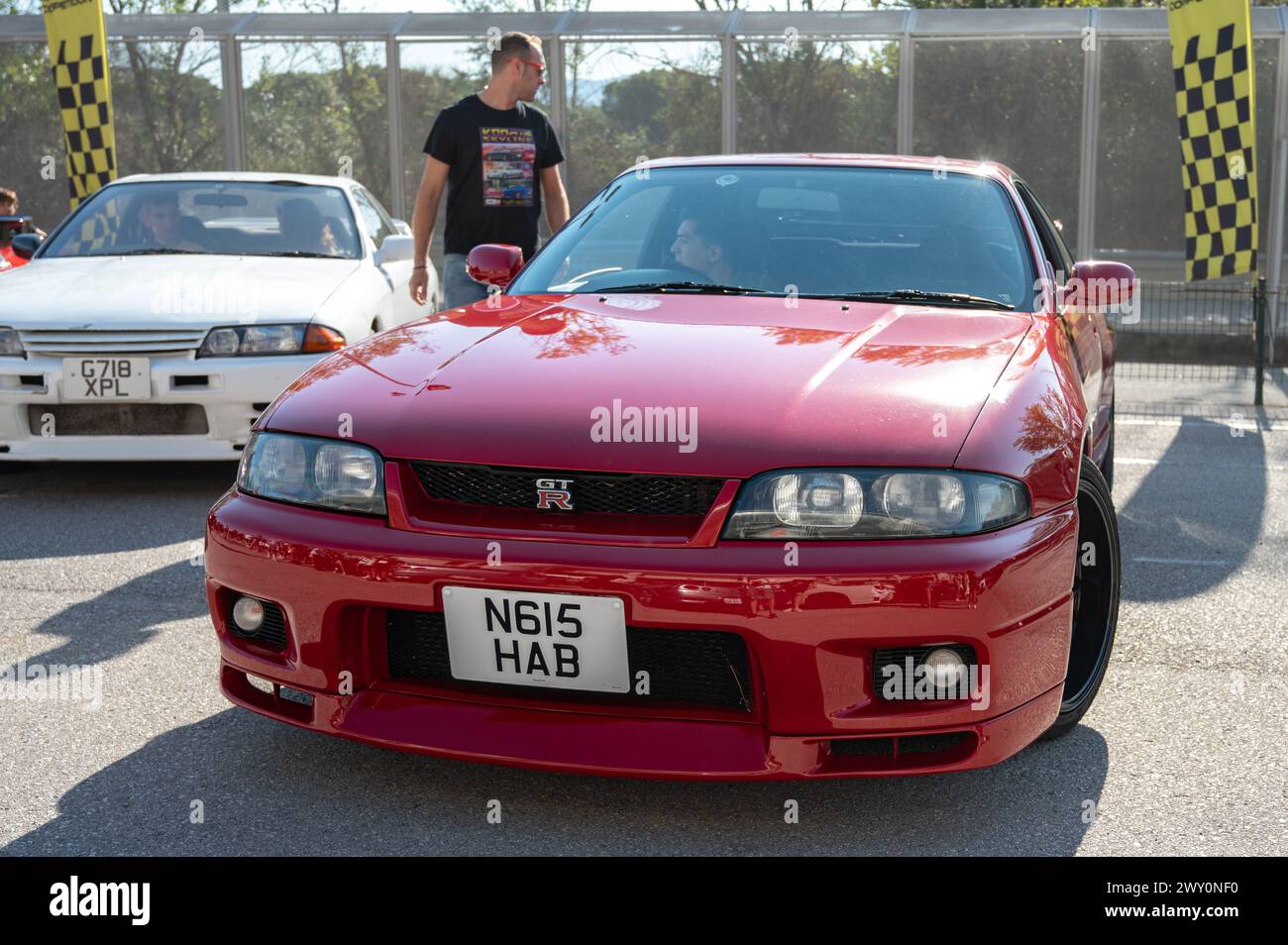 Front view of a red ninth-generation Nissan Skyline GT-R33 at a Japanese sports car meet. Stock Photo