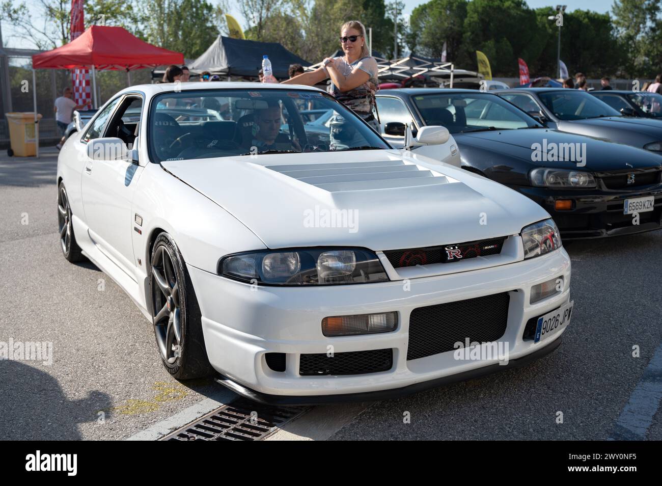 Front view of a white ninth-generation Nissan Skyline GT R33 at a Japanese sports car meet. Stock Photo