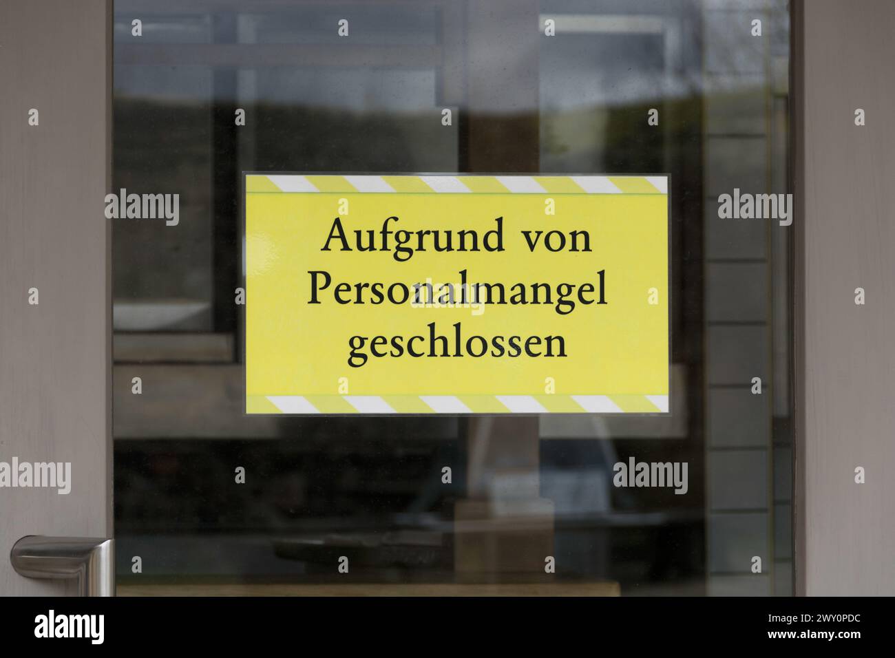 Information sign in German: Aufgrund von Personalmangel geschlossen (Closed due to staff shortages) Stock Photo