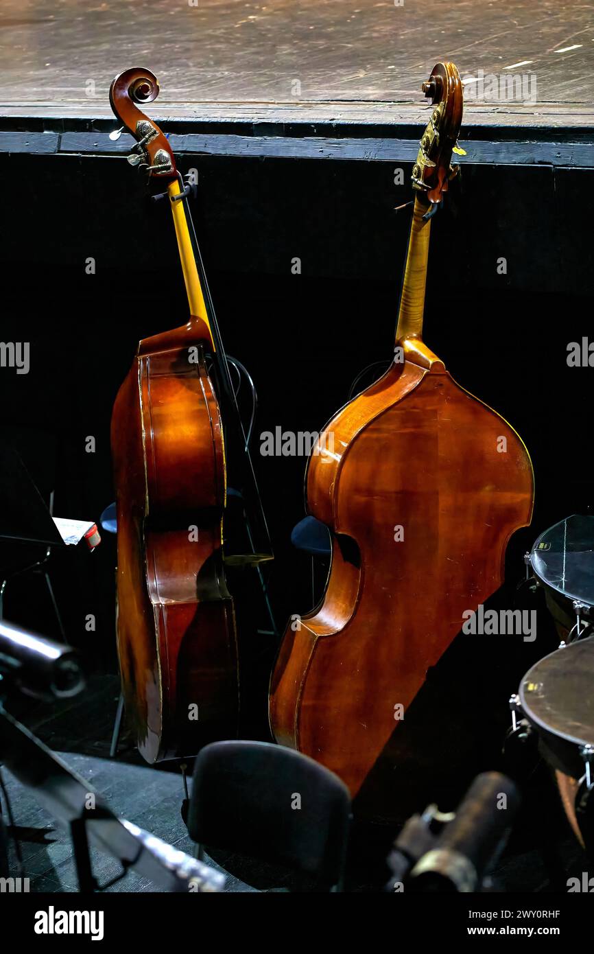 Image of two double basses standing in the orchestra pit of a theater Stock Photo