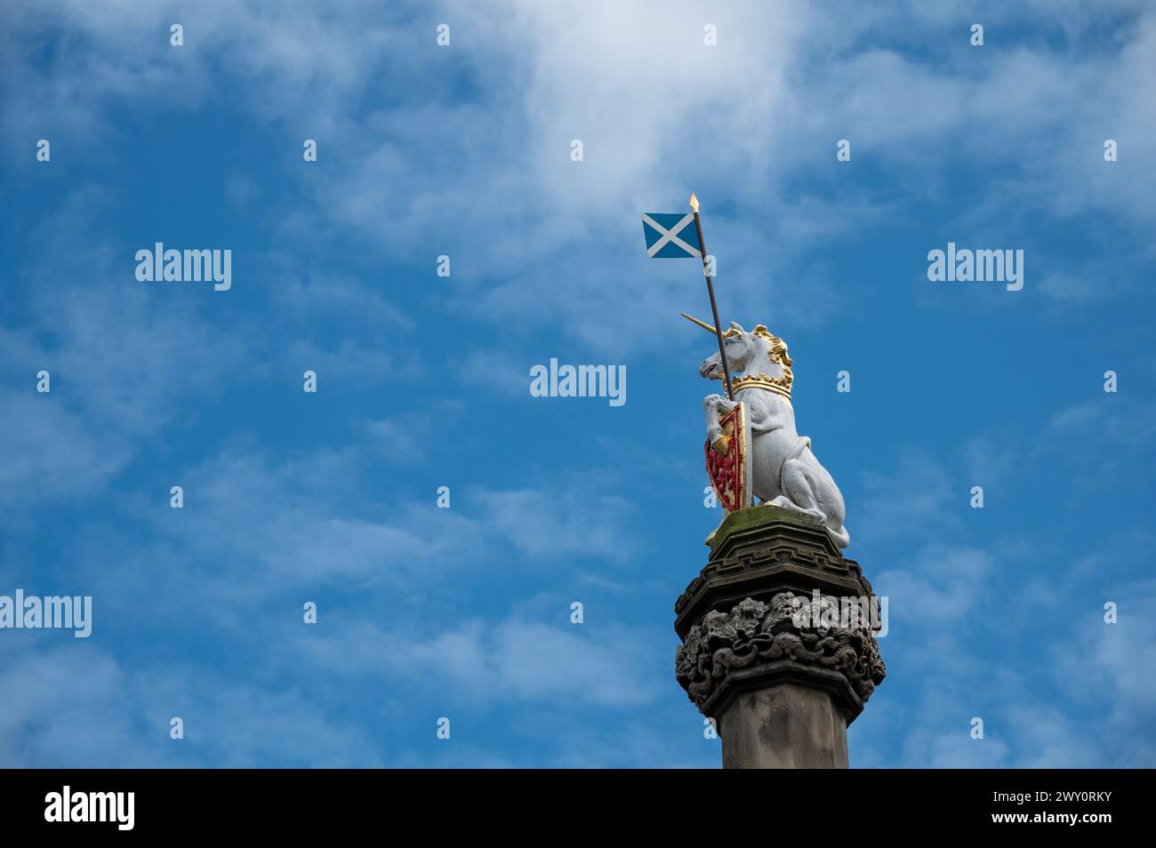 The Unicorn - Scotland’s national animal - holding the Flag of Scotland , cloudy sky, Royal Mile, Edinburgh, Scotland, UK Stock Photo