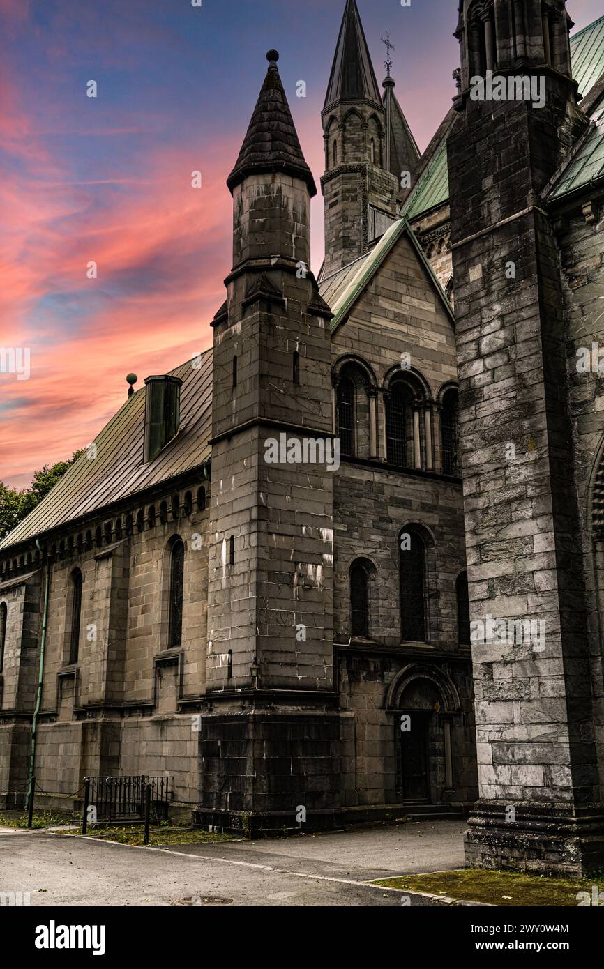 Nidaros Cathedral chapter house sacristy with Spires at Dusk, evening hues of pink red sky over towers. Tourist travel destination in Trondheim Norway Stock Photo