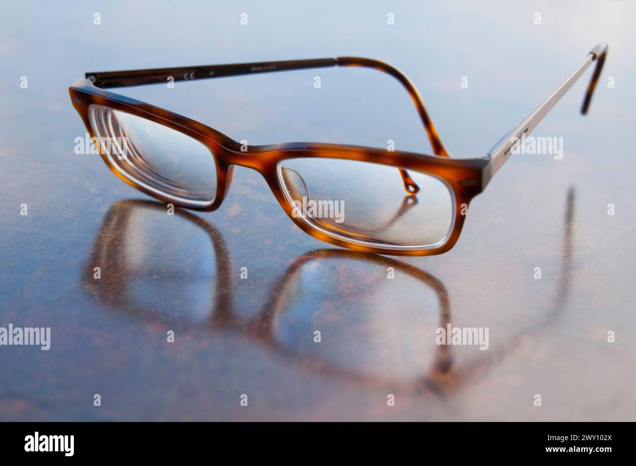 Spectacles and its reflection on marbre surface. Stock Photo